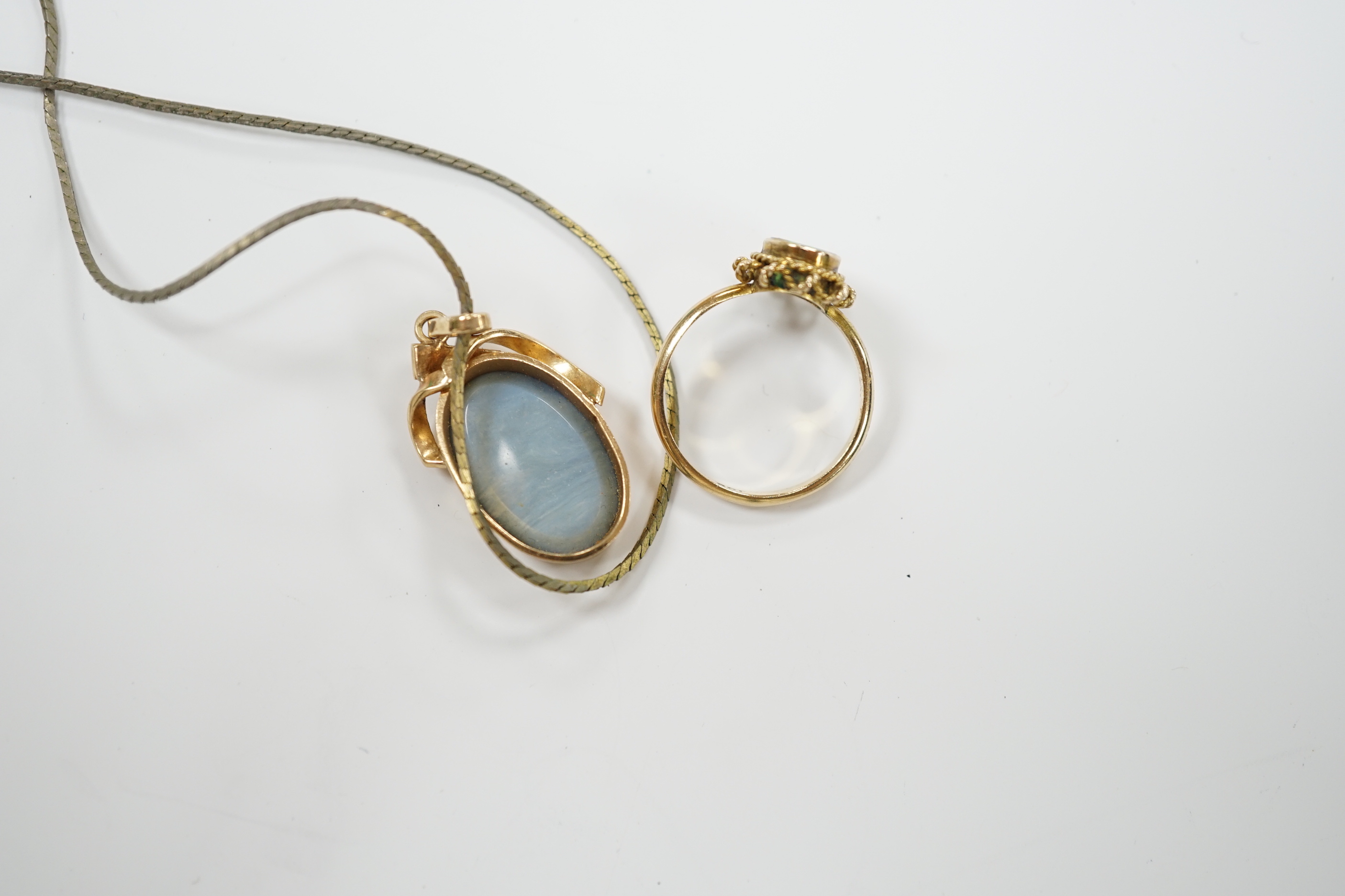 A 9ct and black opal doublet set oval ring, size L and a yellow metal and black opal doublet set pendant, on a gilt metal chain.